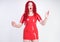 Real doll woman wearing red latex rubber dress and posing on white studio background alone. curvy plus size adult girl standing as