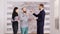 Real estate agent in business suit giving keys to young couple