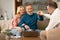 Real Estate Agent Giving Keys To Cheerful Senior Spouses Indoor