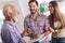 Real estate agent giving keys to couple of customers