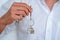 Real estate agent handing over house keys, Men hand holding key with house shaped keychain, Close up focus