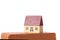 Real estate concept: toy house rest on the top of a brick isolated on white back with clipping path and copy space for your text