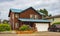 Real Estate Exterior Front House. Big wooden custom house front yard and driveway to garage on summer day in Oregon USA