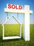Real estate home sold concept sign with sky background.