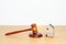 Real Estate Law, Home Insurance, property Tax, Auction and Bidding concepts. small toy house model with gavel justice hammer on
