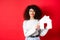 Real estate. Smiling caucasian woman with curly hair and red lips, showing paper house model, searching property