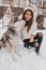 Real friendship of amazing young woman enjoying winter time with husky dog. Pretty charming girl enjoying snow outdoor
