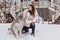 Real friendship, lovely happy moments of charming young woman with cute husly dog enjoying cold winter time on street