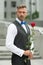 Real gentleman holding rose in hand. be my valentine. womens day concept. Man with Rose flower. man in formalwear