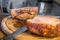 Real hearty homemade roast pork is cut into portions on a wooden board in the kitchen, Germany