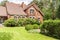 Real photo of garden with bushes and beautiful brick house