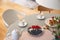 Real photo with high angle of dining table with fresh flowers, jug, coffee cups and plate with fruits