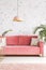 Real photo of a pink sofa with pillows, chandelier and patterned