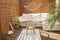 Real photo of relaxing boho zone in home. Wooden floor on terrace with comfy furniture and green plants. Decoration concept