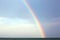 Real rainbow after the storm over the ocean and the blue sky