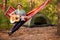 Real relaxation. Handsome young man in hat play guitar while lying in hammock