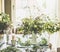 Real summer bouquet made from field wild flowers on a table in a modern living room by the window.