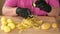 Real time video of a womans hands in black gloves to peeling potatoes