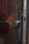 Real wooden door with a hand-wrought iron handle. Wood with iron for background. A wooden texture with an iron lock of old times.