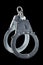 real zinc plated steel police handcuffs closed, isolated on black background