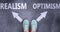 Realism and optimism as different choices in life - pictured as words Realism, optimism on a road to symbolize making decision and