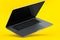 Realistic aluminum laptop with empty white screen isolated on yellow background.