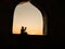 A realistic Arabian interior miniature with window and columns. Silhouette of muslim praying on carpet near window. Festive