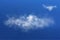 Realistic big white cloud flying on the blue sky and one another little cloud shining in the sunlight. Vector cloudscape