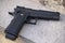 Realistic black airsoft gun lying on stone outdoors