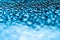 Realistic blue water droplets condensed for creative design on a glass