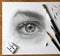 Realistic drawing of a human eye. The process of working on the artistâ€™s desktop with art materials