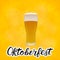 Realistic glass of beer on bright yellow orange background and hand drawn lettering Oktoberfest. Lager beer froth and bubbles. Pub