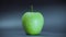 Realistic green apple spinning on black background