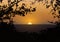 Realistic illustration of sunset on the orange evening sky. Silhouette of tree branches and landscape with forest in the