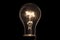 Realistic light bulb on the black background. Lamp light in the