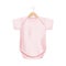 Realistic light pink baby onesie shirt mockup on wooden hanger