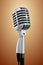 Realistic microphone metallic vintage style on prange lit background