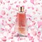 Realistic perfume bottle and flying pink petals background