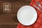 Realistic plate horizontal illustration. white clean plate on wooden table with knife and fork wishing you Bon appetit