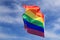 Realistic rainbow flag of LGBT organization waving against sky. LGBT pride flags include lesbians, gays, bisexuals and transgender