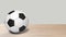 Realistic soccer ball spinning in center on wood table wooden. Footage of a rotating football ball isolated for your video editing