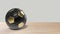 Realistic soccer gold yellow ball spinning in center on wood table. Footage of a rotating football ball isolated for your video