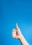 Realistic thumb up hand gesture on blue background with copy space. Like. Good feedback, positive reaction. Validation