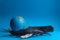 Realistic toy humpback whale and sperm whale with a model of the earth on a blue background