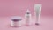 Realistic white cosmetic bottles with purple caps on gently pink background. Cosmetic cream containers and tubes for