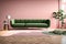 the realm of modern interior design with a striking green sofa set against an empty pink wall background