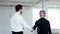 Realtor man meets with businessman to discuss rent and shake hands, side view. Businessman shakes hands with realtor at