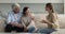 Realtor and older spouses communicating sit on sofa at home