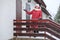 Realtor woman inviting to show the duplex house, standing close to entry door, winter season with snowfall