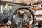 Reapairman with bicycle wheel in the workshop